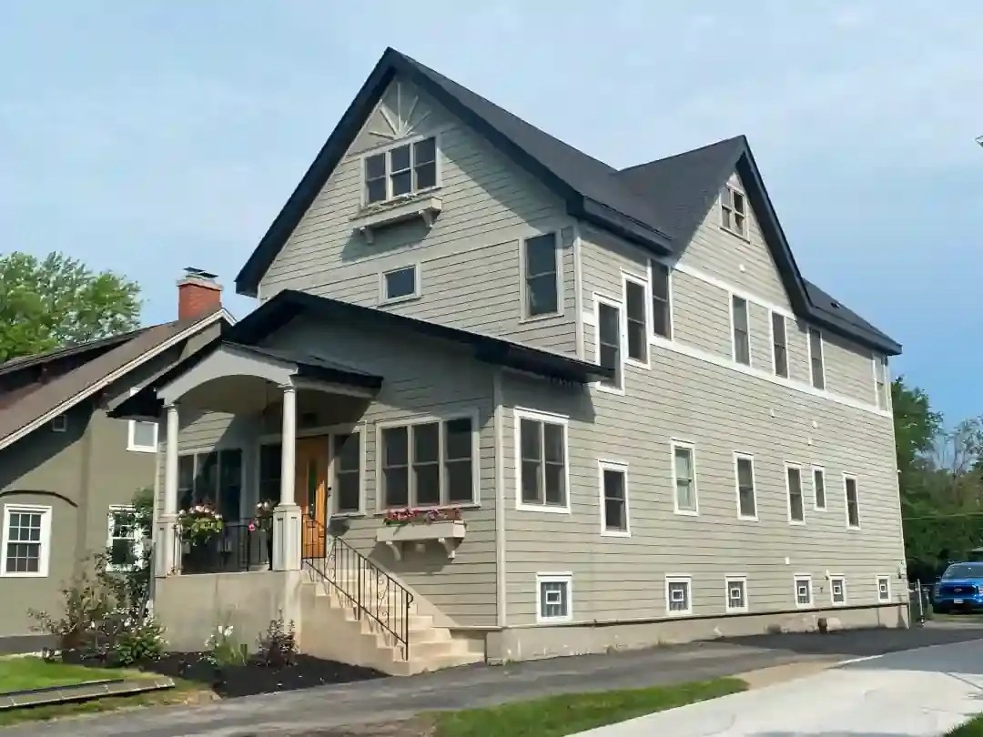 Two-story craftsman house with a new black roof and gray siding
